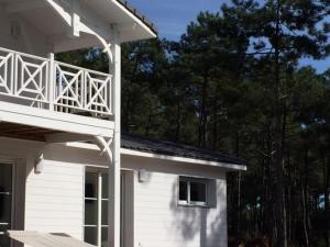 Cette maison blanche dispose d'un balcon sur le côté. dans l'établissement Villa MA&VA, à Lacanau-Océan