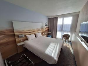 a hotel room with a large bed and a window at ibis Styles Toulon Centre Port in Toulon