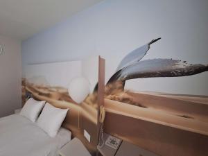 a bedroom with a bed and a picture of an umbrella at ibis Styles Toulon Centre Port in Toulon