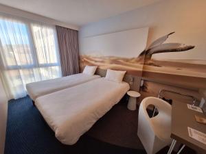a hotel room with two beds and a desk at ibis Styles Toulon Centre Port in Toulon