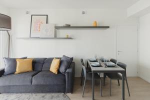 ミラノにあるGoHost - Modern and Bright Apartments with Terrace and Balconyの青いソファとテーブルのあるリビングルーム