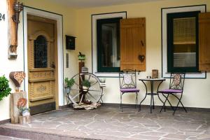 two chairs and a table in front of a house at Stangleggerhof in Wiesing