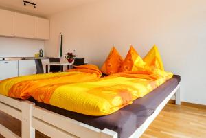 a yellow bed with orange pillows in a room at Anstatthotel Luzern - contactless check-in in Lucerne