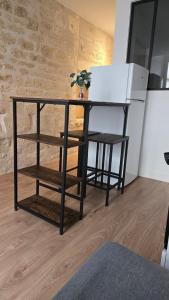 a desk with a chair and a table and a refrigerator at Le Banksy hyper centre avec terrasse in Niort