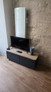 a tv sitting on a table in a room at Le Banksy hyper centre avec terrasse in Niort
