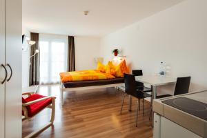Anstatthotel Luzern - self-check-in في لوتزيرن: غرفة نوم بسرير وطاولة مع كراسي