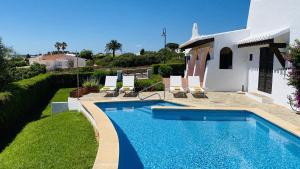 a swimming pool in front of a house at Villa Bini Kim in Binibeca
