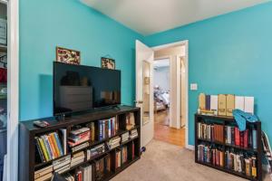 a living room with a tv and book shelves filled with books at Charming Family Retreat with Scenic Views home in Flat Run