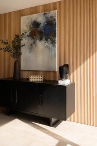 a black cabinet in a room with a painting on the wall at Crisol Suites Condesa in Mexico City