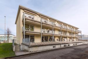 a large building with balconies on the side of a street at Anstatthotel Luzern - contactless check-in in Lucerne