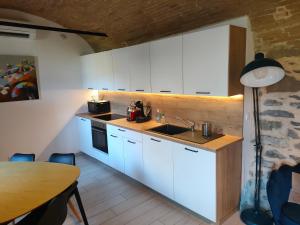 una cucina con armadi bianchi, tavolo e lampada di Studio voûté, atypique a Chambéry