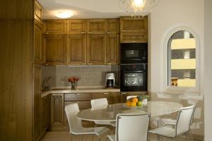 une cuisine avec une table et des chaises et une cuisine avec une fenêtre dans l'établissement Residenz Ambassador A33, à Loèche-les-Bains
