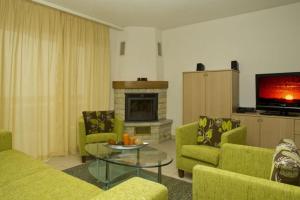 Elle comprend un salon doté d'un mobilier vert et d'une cheminée. dans l'établissement Residenz Ambassador A33, à Loèche-les-Bains