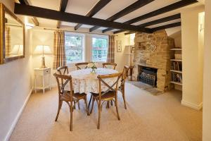 a dining room with a table and chairs and a fireplace at Host & Stay - Ailsa Cottage in Great Broughton +21 photos
