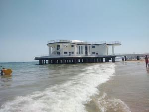 a pier on the beach with people in the water at AFFITTACAMERE LA QUIETE in San Marcello
