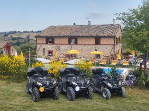 four atvs parked in the grass in front of a building at AFFITTACAMERE LA QUIETE in San Marcello +8 photos