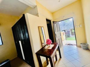 Una habitación con una mesa con un jarrón de flores encima. en Diani Beach Luxury Retreat with 5 Bedrooms, en Diani Beach