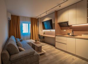 a living room with a couch and a kitchen at Lotus 1 in Ploieşti