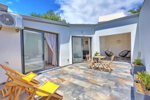 un patio con sillas y una mesa en L'écrin salé, en Étang-Salé