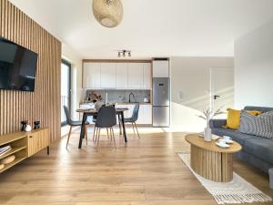 Una sala de estar con un sofá azul y una mesa. en Nowoczesny Apartament Pychowicka 3B, en Cracovia