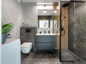 Un baño con lavabo, inodoro y ducha. en Nowoczesny Apartament Pychowicka 3B, en Cracovia 30 fotos más