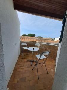 eine Terrasse mit zwei Stühlen und einem Tisch auf einem Balkon in der Unterkunft Océan 40 in Saint-Denis-dʼOléron