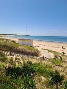 ein Strand mit einem Gebäude und das Meer im Hintergrund in der Unterkunft Océan 40 in Saint-Denis-dʼOléron + 2 Fotos