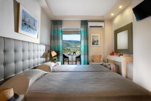 a hotel room with a large bed and a table at Panorama Botsaris Apartments in Syvota