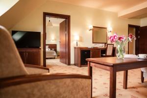 a hotel room with a living room with a hotel room at Hotel Rycerski in Czeladź