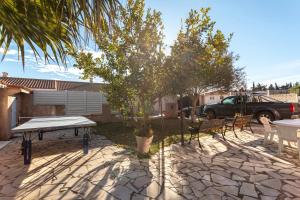 eine Terrasse mit Tisch und Stühlen und einem Baum in der Unterkunft Villa Climatise Avec Grande Piscine in Saint-Laurent-de-la-Salanque