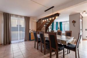 una sala da pranzo con tavolo e sedie di Villa Climatise Avec Grande Piscine a Saint-Laurent-de-la-Salanque