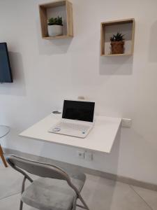 a laptop computer sitting on a white desk at Studio Beauvais avec terrasse privative calme & tout confort in Beauvais +16 photos
