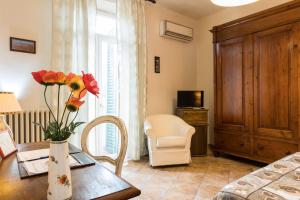 a room with a table with a vase with flowers on it at Locanda dei Fiori in Pistoia