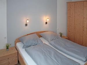 a bed in a bedroom with two pillows on it at Ferienhaus Nr 12, Kategorie Komfort, Feriendorf Hochbergle, Allgäu in Lechbruck