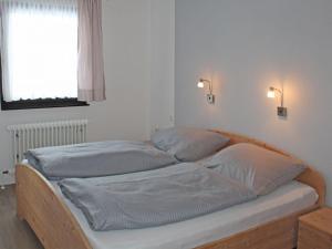 two twin beds in a room with a window at Ferienhaus Nr 12, Kategorie Komfort, Feriendorf Hochbergle, Allgäu in Lechbruck