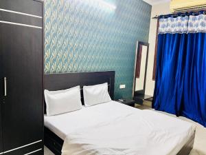 斋浦尔Hotel Omkar的卧室配有白色床和蓝色墙壁