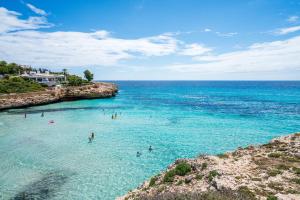 a group of people in the water at a beach at Club Cala Domingos in Calas de Mallorca