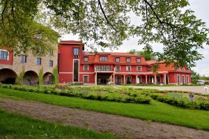 ein großes rotes Gebäude inmitten eines Parks in der Unterkunft Hotel sv. Ludmila in Skalica