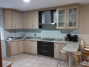 a kitchen with wooden cabinets and a counter top at Casa Alicia in Carnota