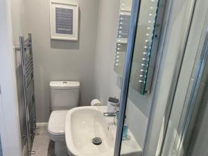 ein kleines Badezimmer mit Waschbecken und Toilette in der Unterkunft Portview in Portrush + 16 Fotos
