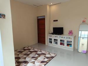 sala de estar con TV y nevera en Than's Homestay Wonosobo, en Wonosobo
