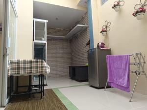 una sala de estar con una toalla morada en una mesa en Than's Homestay Wonosobo, en Wonosobo