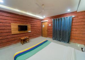 a bedroom with a bed and a tv in it at Salt Water Resort in Dapoli