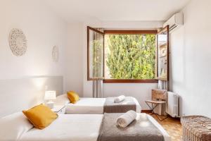 ein Zimmer mit zwei Betten und einem Fenster in der Unterkunft Villa Palma in Palma de Mallorca + 18 Fotos