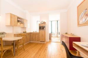 a kitchen with wooden cabinets and a table with chairs at 3 Wellenzauber in Rostock +10 photos