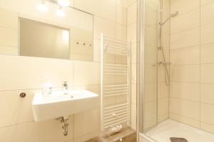 a white bathroom with a sink and a shower at 2 Meerestraum in Rostock +9 photos