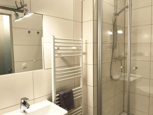a bathroom with a shower and a sink and a mirror at 5 Meereslust in Rostock +14 photos