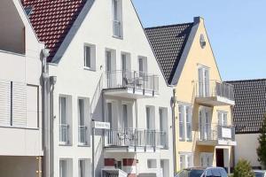 a row of white houses with balconies and a car at Skipperlodge - Versteck am Strom in Warnemünde