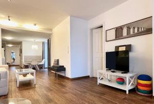 a living room with a flat screen tv and a couch at Skipperlodge - Versteck am Strom in Warnemünde