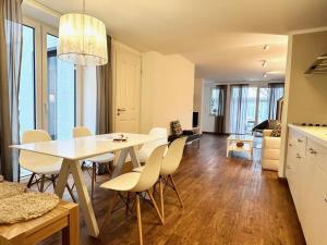 a kitchen and dining room with a white table and chairs at Skipperlodge - Versteck am Strom in Warnemünde